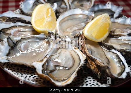 Ostriche fresche sul mercato francese settimanale, cibo di strada, porzione di ostriche aperte con limone, pesce, Francia, primo piano Foto Stock