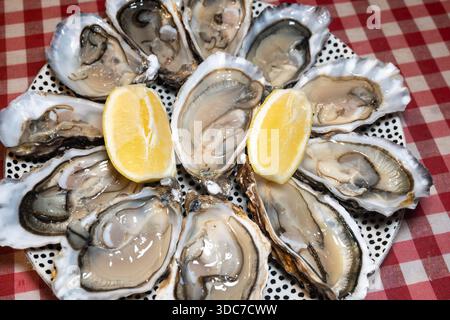 Ostriche fresche sul mercato francese settimanale, cibo di strada, porzione di ostriche aperte con limone, pesce, Francia, primo piano Foto Stock