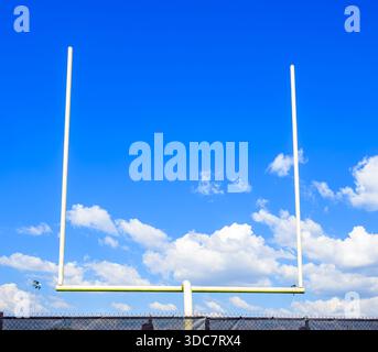 Pali di gol di calcio contro un cielo parzialmente nuvoloso Foto Stock