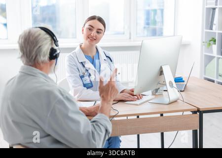 Paziente con cuffie audiometriche sottoposto a test uditivo in clinica Foto Stock