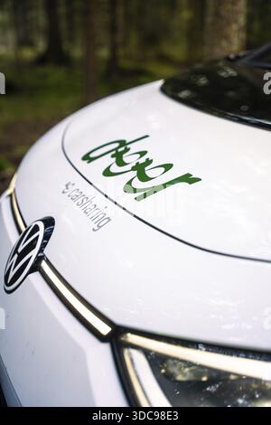 Vista ravvicinata del cofano di un'auto con logo di car sharing nella foresta, Deer e- Carsharing, VW ID3, Calw, Germania Foto Stock