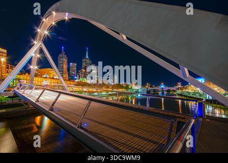 Evan Walker Bridge illuminato di notte che incornicia lo skyline del CBD di Melbourne sul fiume Yarra, Victoria, Australia. Foto Stock