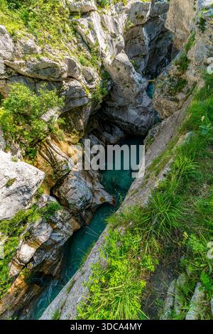 Una vista aerea mozzafiato cattura la serena bellezza delle acque color smeraldo che si infrangono tra gli aspri canyon, evocando avventura e tranquillità in sloveno Foto Stock