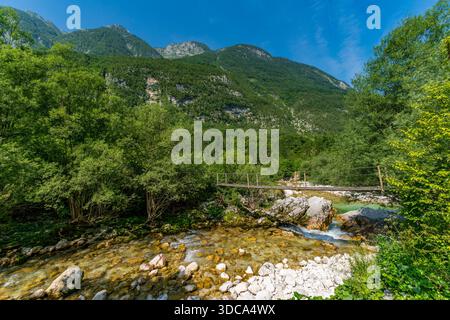 Una tranquilla escursione cattura l'essenza della bellezza della natura mentre un ponte di legno attraversa il fiume Lepenjica, che conduce verso la maestosa Sunik Waterfa Foto Stock