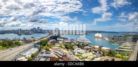 Sydney, Australia - 8 febbraio 2023: Un panorama del porto di Sydney, con il ponte, l'Opera House, Circular Quay. Luna Park e l'esclusivo quartiere o. Foto Stock