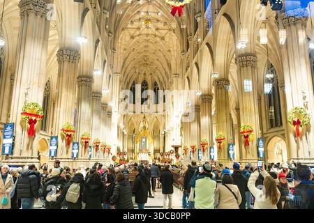 Folla all'interno della cattedrale di San Patrizio decorata per Natale a New York City Foto Stock