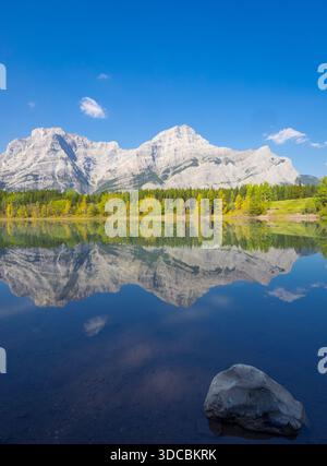 Crolla i colori e i riflessi al laghetto a cuneo con il monte Kidd che si innalza sullo sfondo. Kananaskis Country, Alberta, Canada. Foto Stock