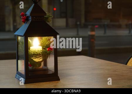 Lanterna con candela. Decorazioni natalizie su un tavolo all'aperto di un caffè a Bucarest. Foto Stock