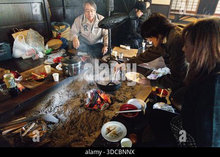 La gente del posto cucina in un irori a Ichikokutochi Tateba Chaya, tra Tsumago-juku e i villaggi Magome lungo il Nakasendo Trail, Nagano, Giappone Foto Stock