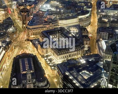 Vista aerea della Bank of England di notte, che mostra calde luci stradali in contrasto con le sagome scure degli edifici nel quartiere finanziario di Londra. Foto Stock