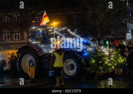 Trattore decorato con luci natalizie e un albero di Natale illuminato in una sfilata festosa notturna Tractors and Tinsel Run Devizes Wiltshire dicembre 2025 Foto Stock