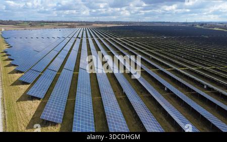 Vista aerea di file di pannelli solari in una grande fattoria solare che produce energia elettrica rinnovabile Foto Stock