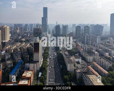 Veduta aerea dei grattacieli della città che penetrano attraverso il cielo nebbioso, gettando lunghe ombre sulle vivaci strade sottostanti, Changsha, Hunan, Cina. Foto Stock