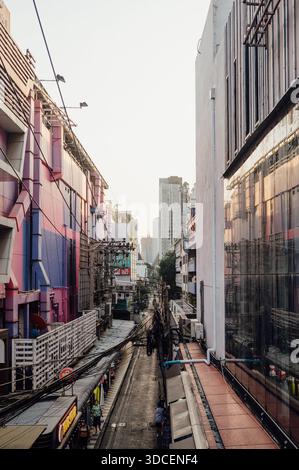 Vicolo urbano stretto con edifici colorati a Bangkok al tramonto Foto Stock