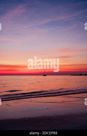 Rosa e viola tramonto sul mare calmo con barche a vela a Koh Chang Foto Stock