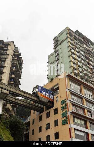 Vista di un treno monorotaia che attraversa il cuore della vita urbana, perfettamente integrato nell'architettura, creando un'eterea danza del movimento, C. Foto Stock