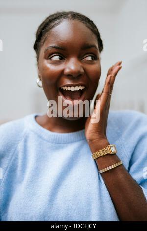 Sorpresa giovane donna con la bocca aperta che dà uno sguardo laterale Foto Stock