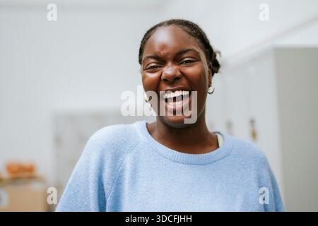Ritratto di una giovane donna allegra che indossa un maglione cardigan blu Foto Stock