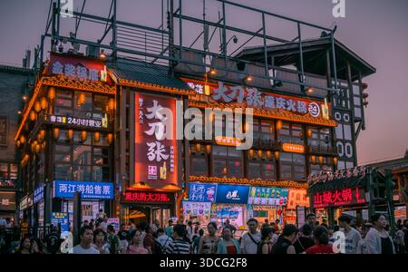 Insegne colorate illuminate e negozi all'interno della grotta di Hongya nel centro di Chongqing, Cina Foto Stock