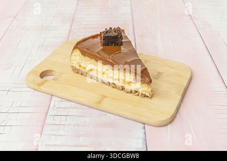 Fetta individuale di cheesecake con centro cioccolato fuso, servita calda con gelato alla vaniglia che si scioglie al contatto Foto Stock