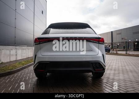 Vista posteriore del Lexus RX bianco 450h più parcheggiato su un vialetto in mattoni bagnati Foto Stock