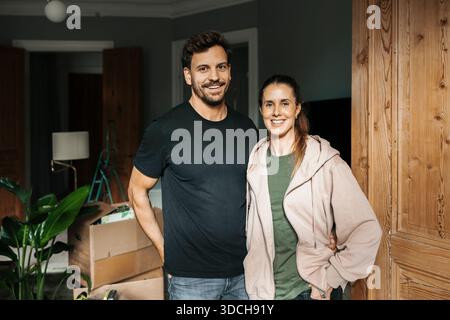 Ritratto di donna sorridente in piedi con l'uomo nella loro nuova casa Foto Stock