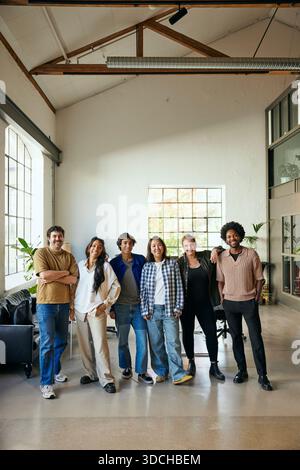 Ritratto di professionisti tecnologici sorridenti, uomini e donne, affiancati in un nuovo ufficio Foto Stock