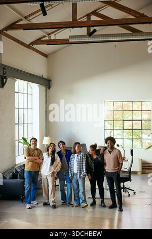 Esperti di tecnologia maschili e femminili che si divertono mentre si trovano fianco a fianco nel nuovo ufficio Foto Stock