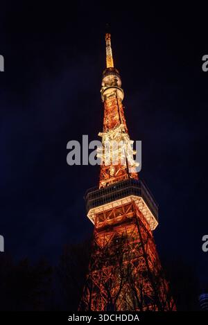 Torre Tokyo superiore illuminata contro il cielo notturno. Vista ravvicinata della Tokyo Tower superiore e della piattaforma di osservazione arancione illuminante contro un profondo cielo notturno. Foto Stock