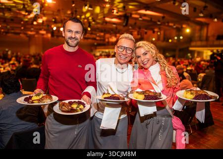 abb: David Biethig, Sascha Lauterbach und Victoria Herrmann als Promi Kellner beim Servieren von Teller mit Gaensekeuele Rotkohl und Kloesse bei der 31. Frank Zander Weihnachtsfeier Weihnachtsessen fuer Obdachlose und Beduerftige Menschen 2025 im Estrel Convention Center AM 22.12.2025 a Berlin Berlin Berlin Deutschland Foto Stock