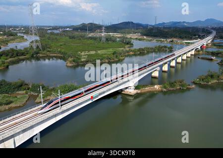 (251223) -- PECHINO, 23 dicembre 2025 (Xinhua) -- Un treno proiettile corre su un ponte lungo la Guangzhou-Zhanjiang High-Speed Railway nella provincia del Guangdong della Cina meridionale, 22 dicembre 2025. La ferrovia ad alta velocità Guangzhou-Zhanjiang, che si estende per circa 401 chilometri, ha iniziato a funzionare lunedì. (Foto di Wei Jie/Xinhua) Foto Stock