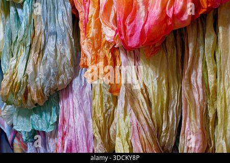 Sciarpe in seta, scialli e scollati in vari colori, foto ravvicinata, sfondo in tessuto astratto Foto Stock