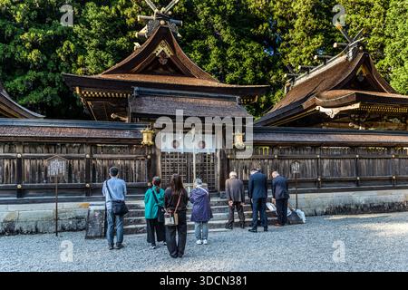 Pellegrini in preghiera al santuario Kumano Hongu Taisha, costruito in architettura tradizionale giapponese a Tanabe, prefettura di Wakayama, Giappone Foto Stock