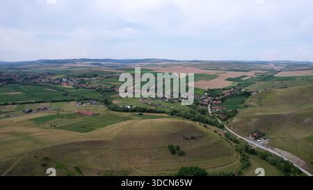 Viaggia in romania transilvania cheile turzii vista aerea di un villaggio rumeno circondato da campi agricoli e colline ondulate Foto Stock