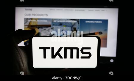 In questa immagine, una persona ha in mano un cellulare con il logo dell'azienda ThyssenKrupp Marine Systems (TKMS) sullo schermo davanti alla pagina Web. Foto Stock
