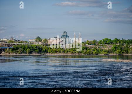 La National Gallery of Canada e la basilica della cattedrale di Notre Dame si innalzano sopra gli alberi attraverso il fiume Ottawa sotto un cielo blu. Ottawa, Canada - 16 maggio, 2 Foto Stock