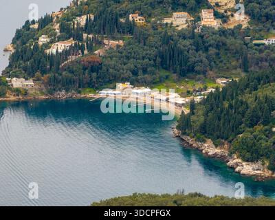Vista panoramica del drone aereo della costa nord-orientale di Corfù in Grecia, che mostra la baia di Kouloura e la costa di Kalami circondati da lussureggianti oliveti A. Foto Stock