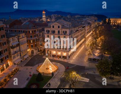 Ampio giro aereo panoramico della città vecchia di Corfù, in Grecia, che mostra il Liston, Piazza Spianada e la Fortezza Vecchia illuminata dalle festività natalizie Foto Stock