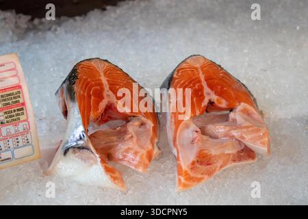 Filetti di salmone freschi esposti su ghiaccio tritato per la vendita presso un banco di pescivendoli Foto Stock