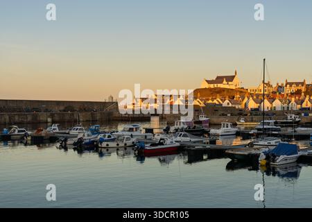 Portknockie, Scozia, Regno Unito. 24 dicembre 2025. Porto di Findochty e Portknockie con barche in acqua. La chiesa riceve l'ultima luce del sole la vigilia di Natale, il 24 dicembre 2025. Crediti: JASPERIMAGE/Alamy Live News Foto Stock