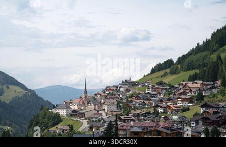 Vista panoramica del paese in Val Gardena, catena montuosa delle Dolomiti italiane in alto Adige, con la torre della chiesa che si innalza sul paese in estate Foto Stock