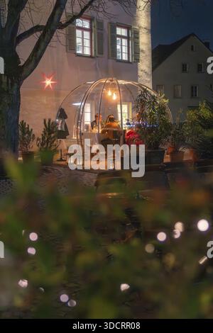 Una cupola illuminata all'aperto di notte con gente che mangia, circondata da piante e luci, Gastro Bubbles, Sindelfingen, Germania Foto Stock