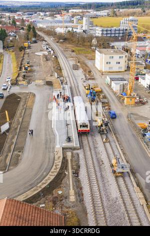 Un cantiere in una stazione ferroviaria con lavori di costruzione, gru e un treno. Edifici residenziali possono essere visti sullo sfondo, evento storico Foto Stock