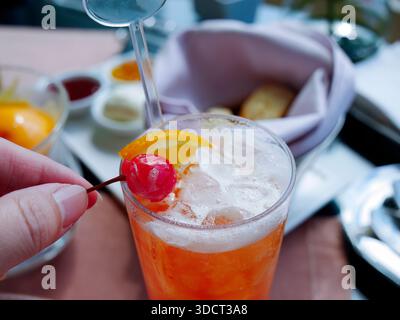 Un vivace punch di frutta rossa o un cocktail servito in un bicchiere alto. Assomiglia a mai Tai, Tequila Sunrise o alla coda di fragole, piena di crys Foto Stock