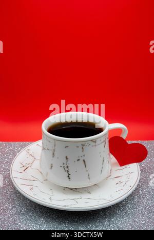 Tazza da caffè con decorazione a cuore rosso. Accogliente concetto di amore e stile di vita per San Valentino. Foto Stock