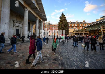 Scena festiva al Covent Garden di Londra il 24 dicembre 2025, con folle di persone che camminano e si godono il mercatino di Natale. Foto Stock