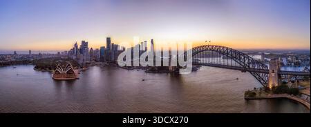 Luce del tramonto dietro il lungomare del CBD di Sydney attraverso il porto dal ponte di Kirribilli con vista aerea della città. Foto Stock