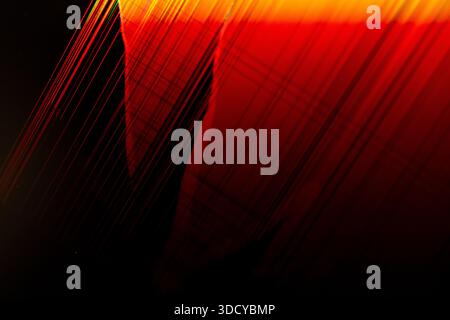 Sfondo astratto dinamico con strisce luminose rosse e arancioni e linee intersecanti, che rappresentano la comunicazione digitale, l'energia e il collegamento Foto Stock