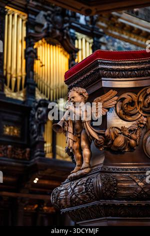 Musicista decorativo cherubino intagliato nel pulpito del Quire, dove il coro e il clero normalmente siedono durante le funzioni, nella Cattedrale di St Paul, Londra, Regno Unito Foto Stock