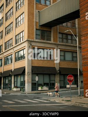 Un uomo cammina il suo cane tra gli edifici industriali di Kansas City, Missouri Foto Stock